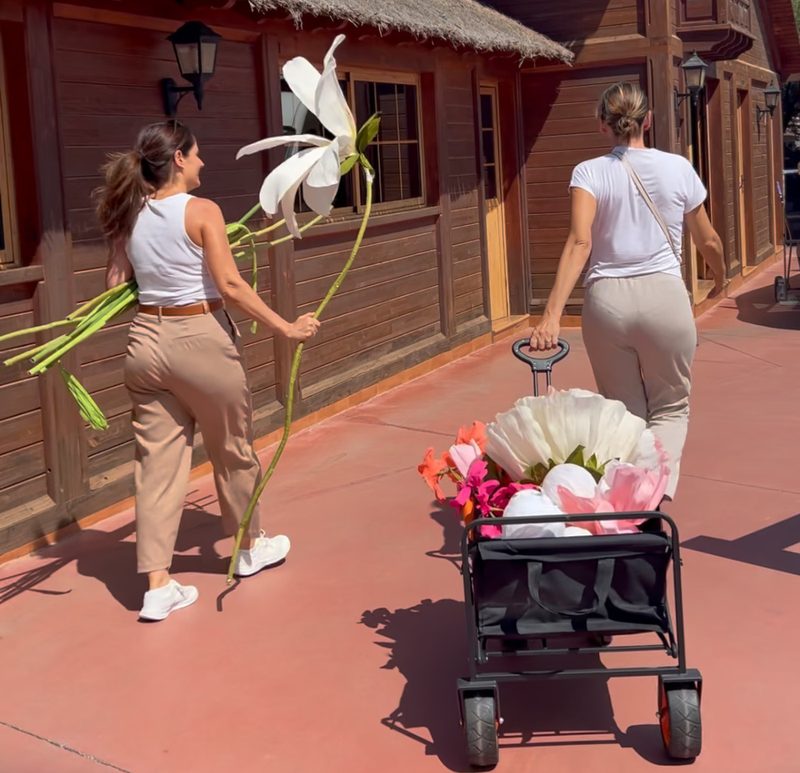 Eszter y Zsófi llevando flores gigantes hechas a mano a un montaje